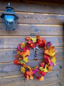 Shows the fall wreath using a metal wire frame and covered with silk autumn leaves